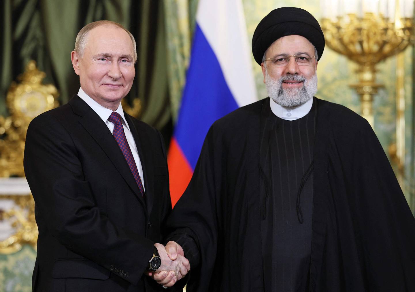 In this pool photograph distributed by Russian news agency Sputnik on December 7, 2023, Russia's President Vladimir Putin (L) shakes hands with Iran's President Ebrahim Raisi during their meeting in the Kremlin in Moscow. (Photo by Sergei BOBYLYOV / POOL / AFP) / Editor's note : this image is distributed by Russian state owned agency Sputnik