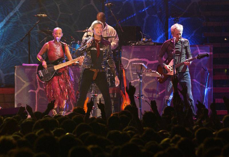 (FILES) This file photo taken on October 20, 2003 shows 
British rock legend David Bowie (C) performs on stage, 20 October 2003 at the Bercy stadium in Paris. At left, US bassist Gail Ann Dorsey. / AFP / BERTRAND GUAY
