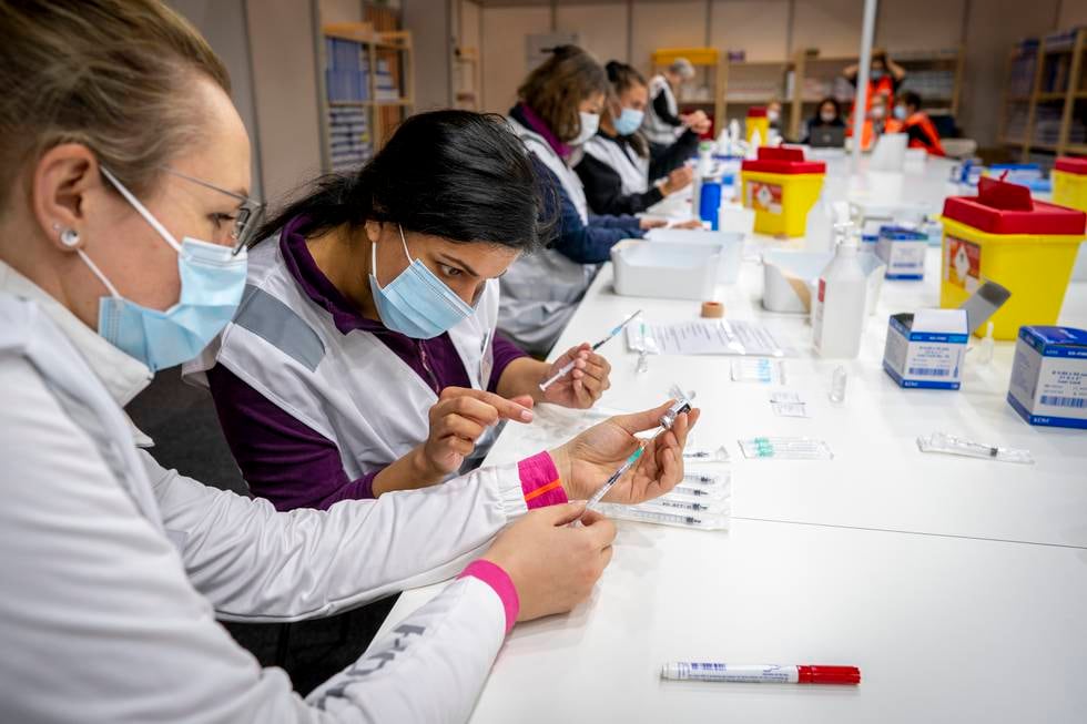 Sykepleiere fra Bærum sjekker ferdig fylte sprøyter med vaksine.