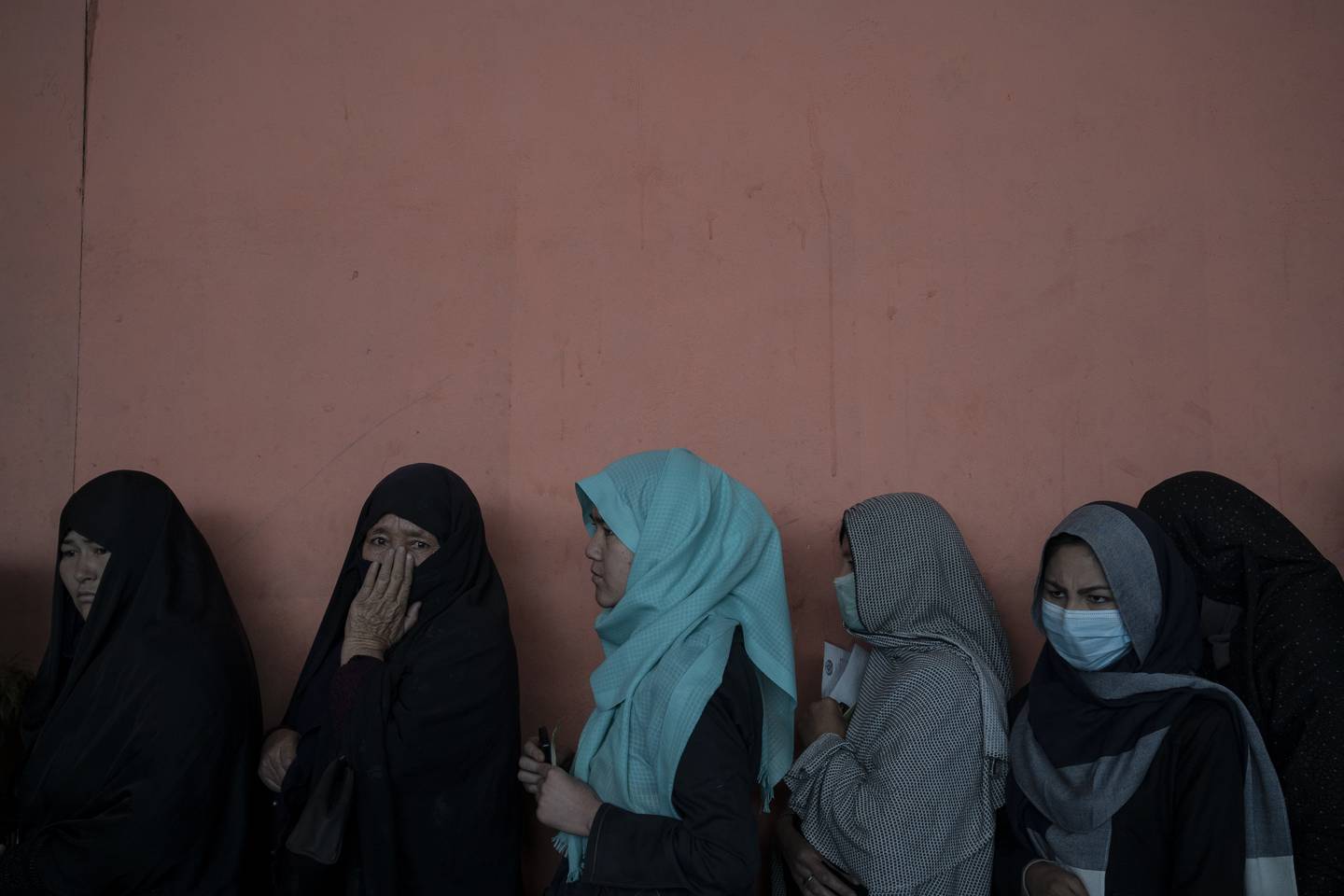 Kvinner venter i kø for å få kontanter i en utdeling organisert av Verdens matvareprogram (WFP) i Kabul.