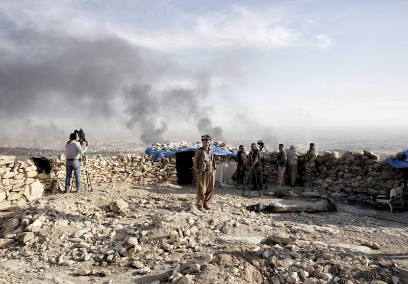Røyken ligger svart over byen Sinjar i Nord-Irak fra oljebrannene krigere fra Den islamske staten IS har tent på. Det var kampen om Sinjar i fjor sommer som fikk USA til å starte de første luftangrepene. FOTO: BRAM JANSSEN/ NTB SCANPIX