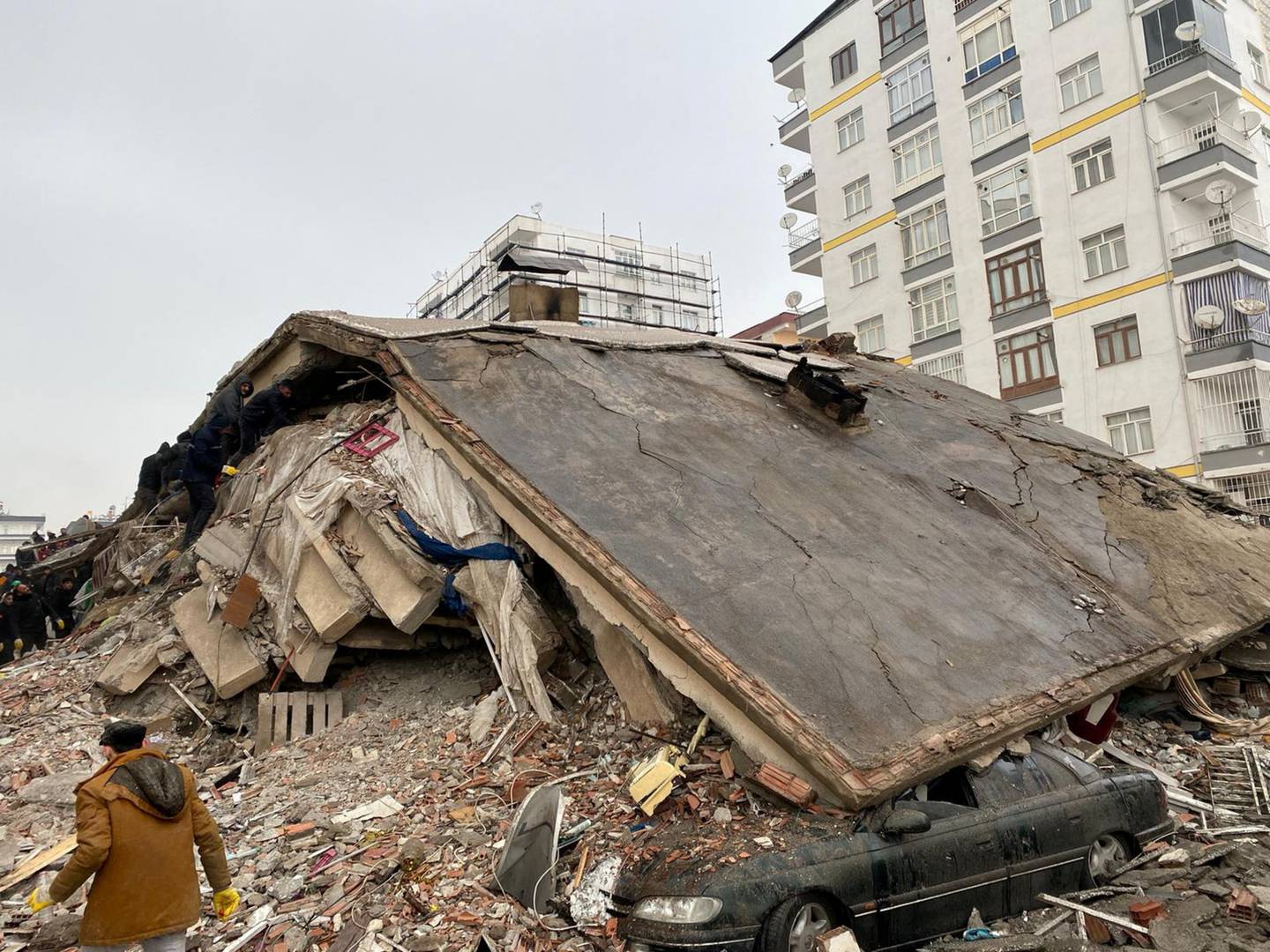 Folk leter i ruinene etter jordskjelvet i  Diyarbakir i Tyrkia.