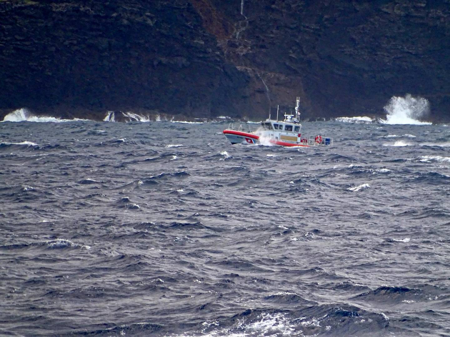 In this photo released by the U.S. Coast Guard, a coast guard vessel searches along the Na Pali Coast on the Hawaiian island of Kauai on Friday, Dec. 27, 2019, the day after a tour helicopter disappeared with seven people aboard. Authorities say wreckage of the helicopter has been found in a mountainous area on the island. (Lt. j.g. Daniel Winter/U.S. Coast Guard via AP)
