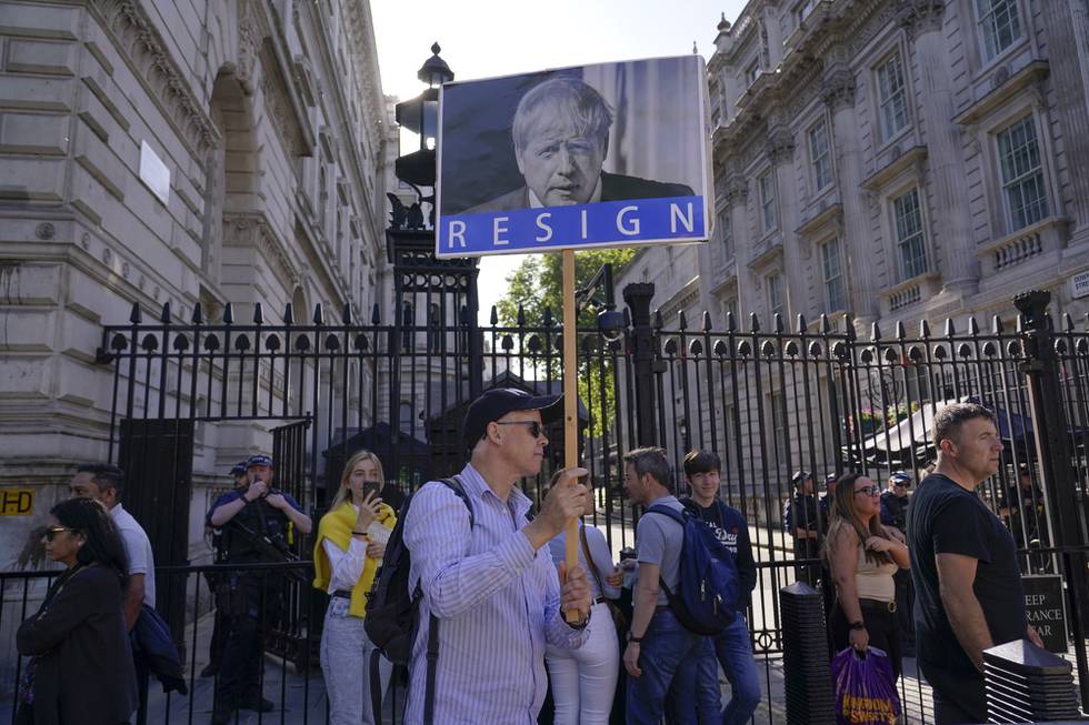 Demonstranter utenfor statsministerboligen i Downing Street fredag 27. mai, med plakater med påskriften «Gå av.»