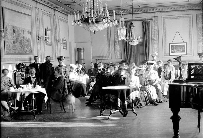 Kristiania var kontrastenes by med store forskjeller mellom fattig og rik, arbeider og borgerskap og øst og vest. Pynta kvinner og menn ved bordene i salongen ved Grefsen sanatorium ca. 1905.