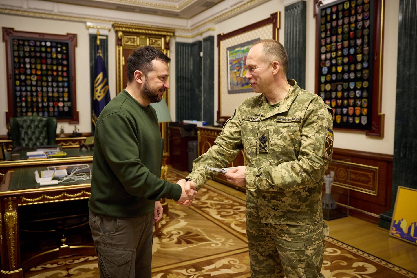 Ukraine's President Volodymyr Zelenskiy and Commander in Chief of the Ukrainian Armed Forces Colonel General Oleksandr Syrskyi shake hands after a meeting with newly appointed top military commanders, amid Russia's attack on Ukraine, in Kyiv, Ukraine February 10, 2024. Ukrainian Presidential Press Service/Handout via REUTERS ATTENTION EDITORS - THIS IMAGE HAS BEEN SUPPLIED BY A THIRD PARTY.
