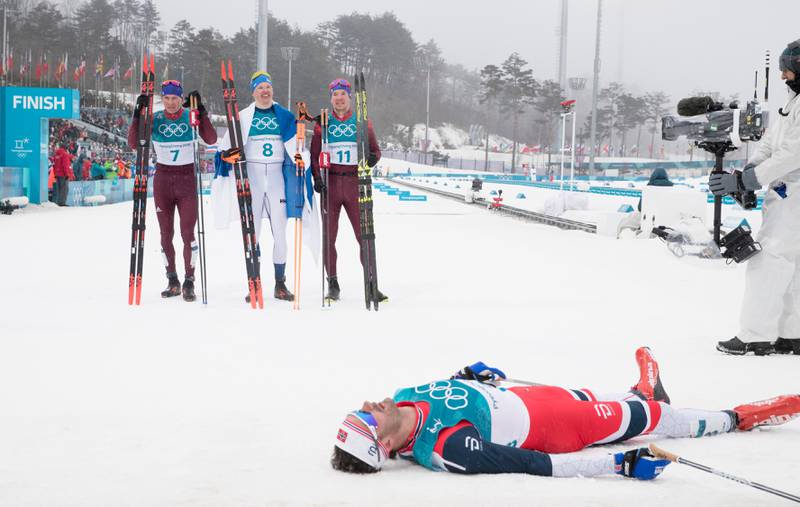 Hans Christer Holund ligger helt utslitt mens medaljevinnerne er klare. Aleksander Bolsjunov, iivo Niskanen og Andrej Larkov.