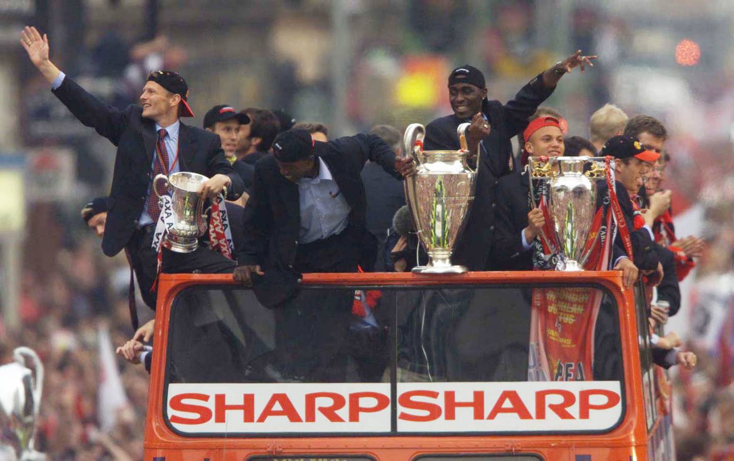 Den gang Manchester United vant alt og kunne feire med tre pokaler på seiersmarsj for fansen gjennom Manchester by: Teddy Sheringham holder trofeet fra FA-cupen, Dwight Yorke holder pokalen fra UEFA Champions Cup og Wes Brown som holder trofeet fra Premier League i 1999.