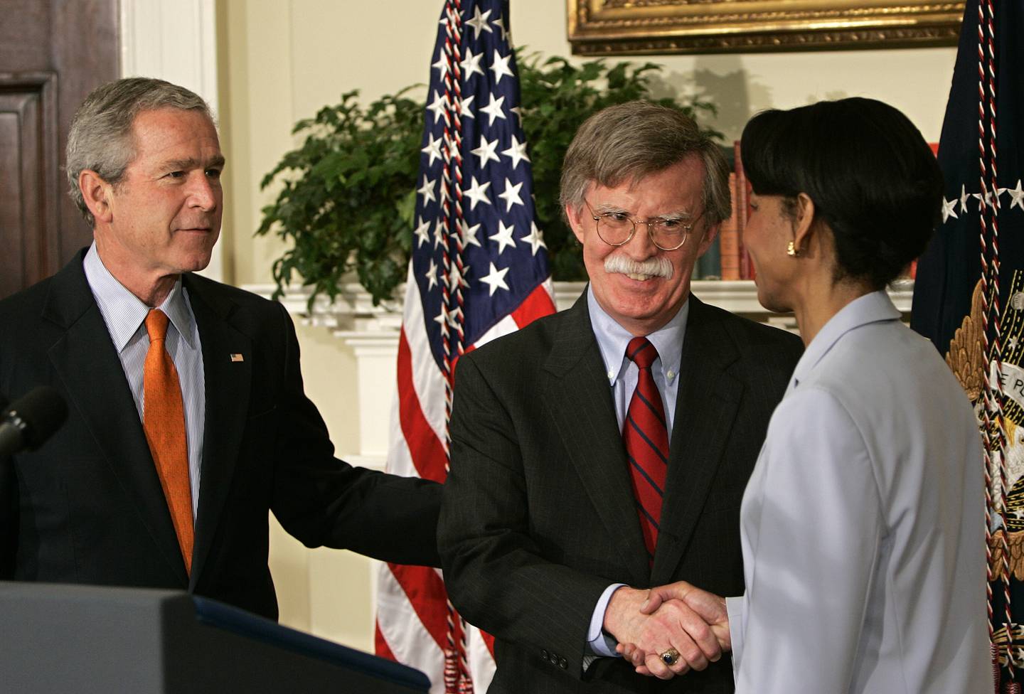 John Bolton (C) is congratulated by US Secretary of State Condoleezza Rice (R) after being installed by President George W Bush (L) as the permanent Ambassador to the United Nations for the US in the Roosevelt Room of the White House 01 August, 2005 in Washington, DC. Bolton has faced harsh criticism by oppenets, and pledged to work for a "stronger, more effective" United Nations while promoting US interests and values at the world body. Bolton, 56, said he would work tirelessly to advance the agenda of President George W. Bush, who appointed him to the post by decree after his confirmation vote in the US Senate was blocked for months. AFP PHOTO/Brendan SMIALOWSKI
