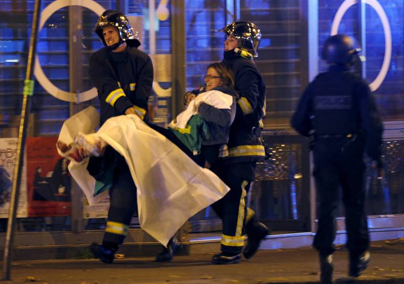 Minst 60 mennesker skal være drept i minst tre væpnede angrep i Paris, og i en konserthall er et hundretall mennesker tatt som gisler, ifølge politiet. Her hjelper franske brigadefolk sårede ved konserthallen Bataclan etter skyting i Paris fredag. Minst 35 er drept. FOTO:  Reuters/Christian Hartmann
