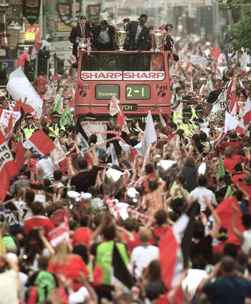 
Manchester United players, from left, Teddy Sheringham, who holds the English FA Cup,  Dwight Yorke, who  holds the UEFA Champions Cup and Andy Cole, who  stands next to the English Premiership Trophy,  pictured right,  during their parade through Manchester city centre atop a double decker bus, as huge crowds cheered the treble-winning Manchester United football team  on Thursday 27th May 1999. The team won the English FA Cup, were top in the English Premier League and on Wednesday won the UEFA Champions Cup when they beat Bayern Munich 2-1, as stated on the front of the bus.  (AP Photo / Str) UNITED KINGDOM OUT 