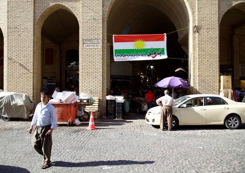 Slagord som oppfordrer til deltakelse i folkeavstemningen er trykket på et kurdisk flagg i Erbil i Kurdistan.