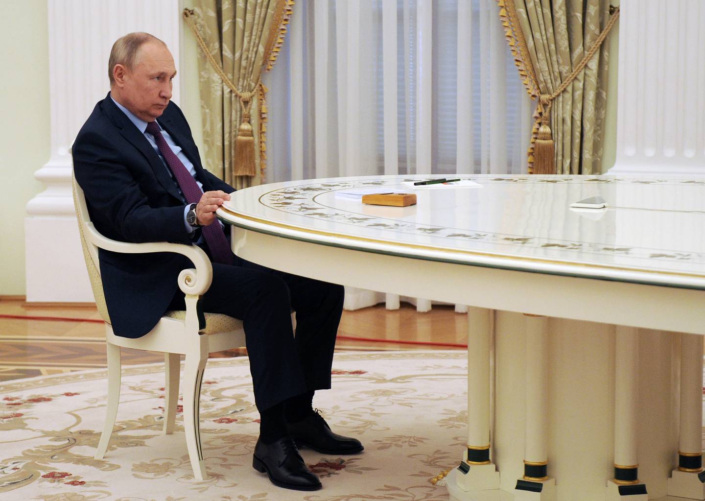 Russlands president Vladimir Putin sitter ved et bord i Moskva.