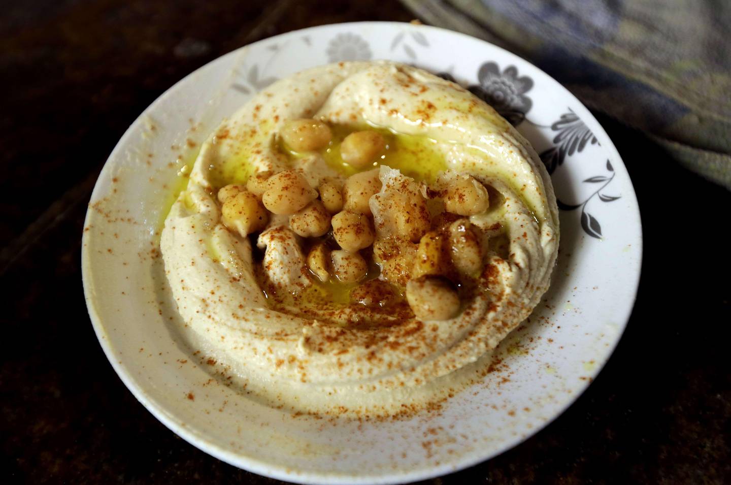 A plate of Hummus is served  at a restaurant in the Lebanese coastal city of Tripoli, north of Beirut on October 20, 2014. Hummus is a Levantine food dip or spread made from mashed chickpeas blended with tahini, olive oil, lemon juice, salt and garlic. Today, it is popular throughout the Middle East, North Africa, and in Middle Eastern cuisine around the globe. AFP PHOTO/JOSEPH EID
