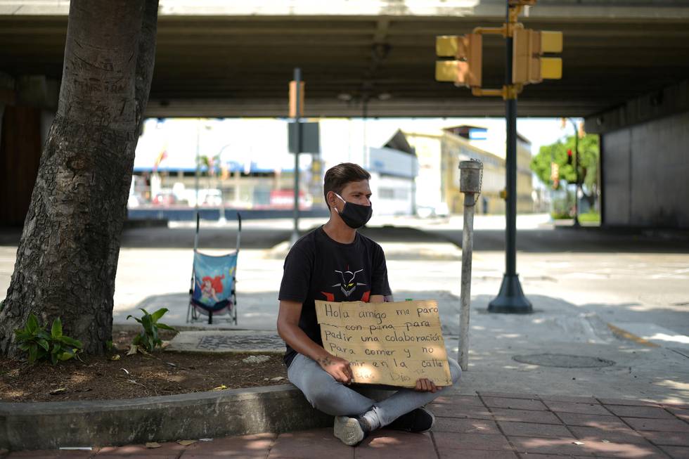 A Venezuelan immigrant makes a plea for money on a street corner to help him and his family return home to Venezuela amid the spread of the coronavirus disease (COVID-19), in Guayaquil, Ecuador April 20, 2020. REUTERS/Vicente Gaibor del Pino
