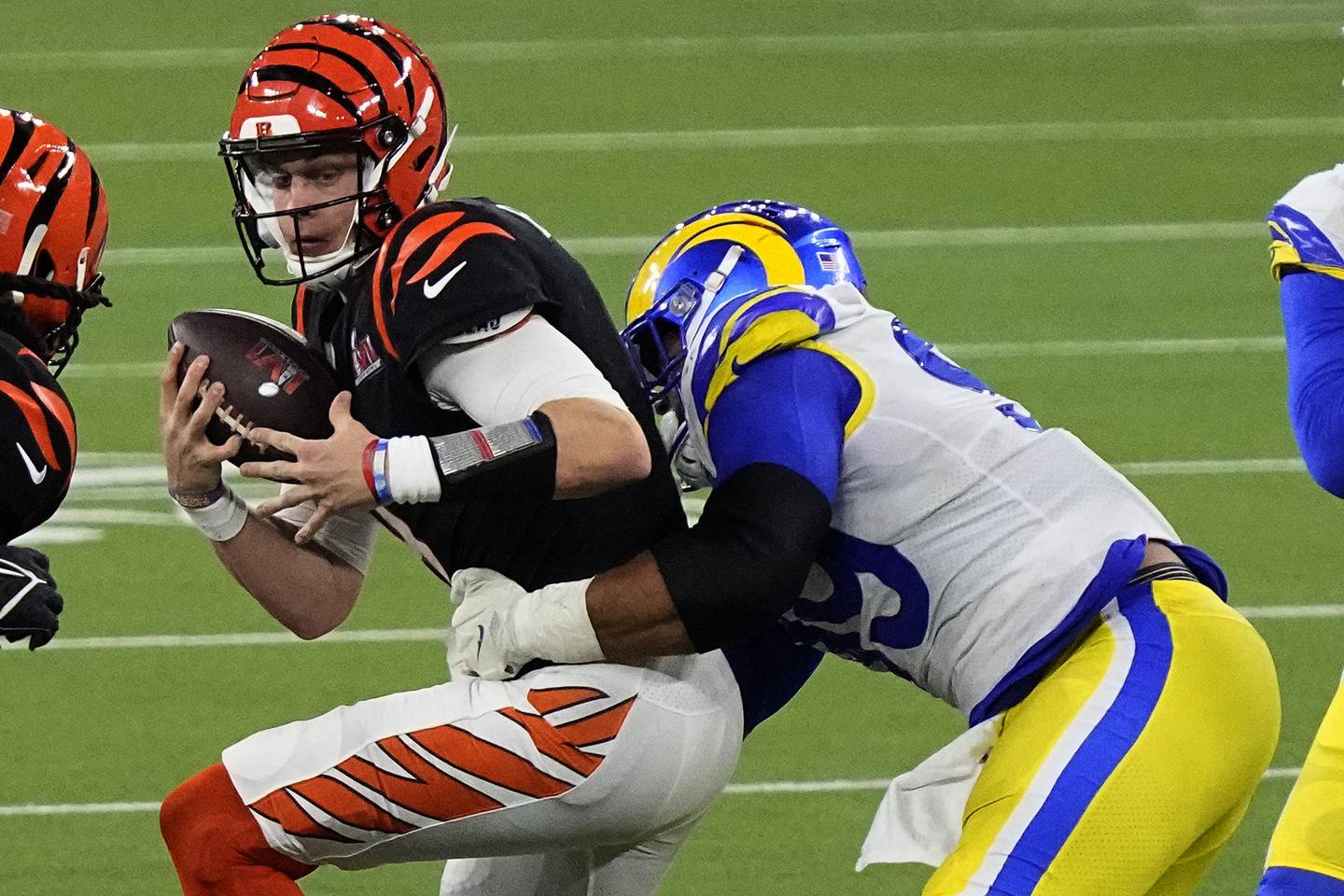 Los Angeles Rams-forsvarer Aaron Donald takler Cincinnati Bengals-quarterback Joe Burrow med ballen i sluttsekundene og avgjør dermed Superbowl i sitt lags favør. Foto: Ted S. Warren, AP / NTB