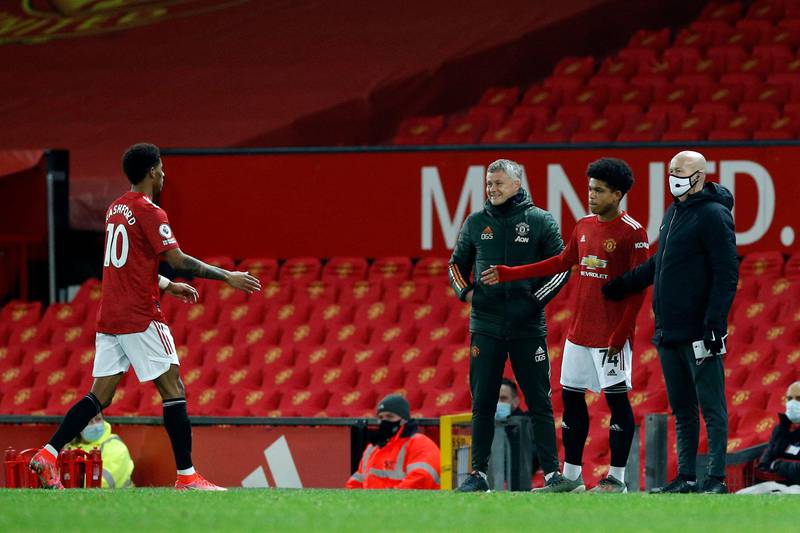 Manchester United's Nigerian midfielder Shola Shoretire (2nd R) prepares to come on to the pitch to replace Manchester United's English striker Marcus Rashford (L) during the English Premier League football match between Manchester United and Newcastle at Old Trafford in Manchester, north west England, on February 21, 2021. (Photo by PHIL NOBLE / POOL / AFP) / RESTRICTED TO EDITORIAL USE. No use with unauthorized audio, video, data, fixture lists, club/league logos or 'live' services. Online in-match use limited to 120 images. An additional 40 images may be used in extra time. No video emulation. Social media in-match use limited to 120 images. An additional 40 images may be used in extra time. No use in betting publications, games or single club/league/player publications. / 