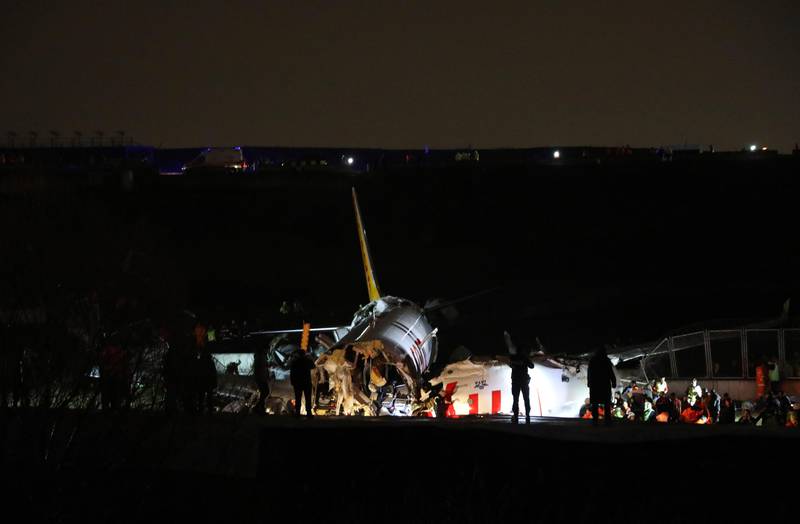 Rescue members work after a plane skidded off the runway at Istanbul's Sabiha Gokcen Airport, Wednesday, Feb. 5, 2020. A plane skidded off the runway Wednesday at Istanbuls Sabiha Gokcen Airport, crashing into a field and breaking into pieces. Passengers were seen evacuating through cracks in the plane and authorities said at least 21 people were injured. (AP Photo)