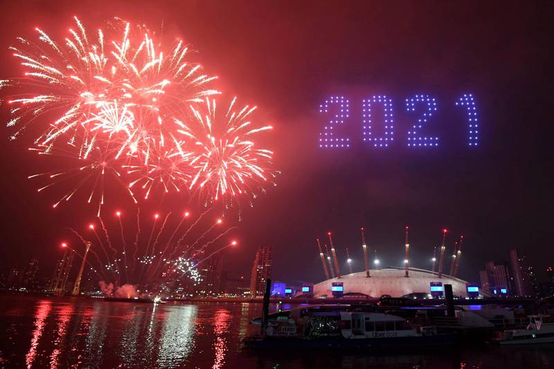 Fireworks and drones illuminate the night sky over London as they form a light display as London's normal New Year's Eve fireworks display was cancelled due to the coronavirus pandemic Thursday Dec. 31, 2020. (Victoria Jones/PA via AP)