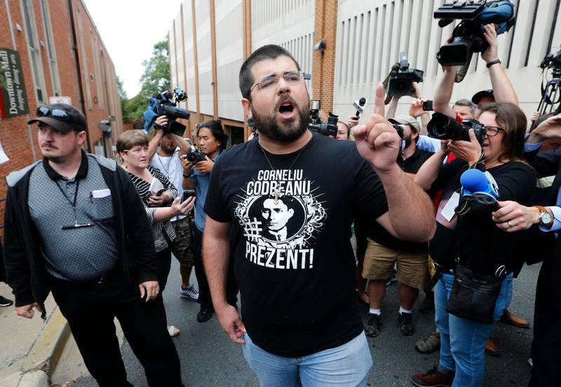 CORRECTS LAST NAME TO HEIMBACH FROM HEINBACH - Matthew Heimbach, center, voices his displeasure at the media after a court hearing for James Alex Fields Jr., in front of court in Charlottesville, Va., Monday, Aug. 14, 2017. A judge has denied bond for Fields accused of plowing his car into a crowd at a white nationalist rally. (AP Photo/Steve Helber)