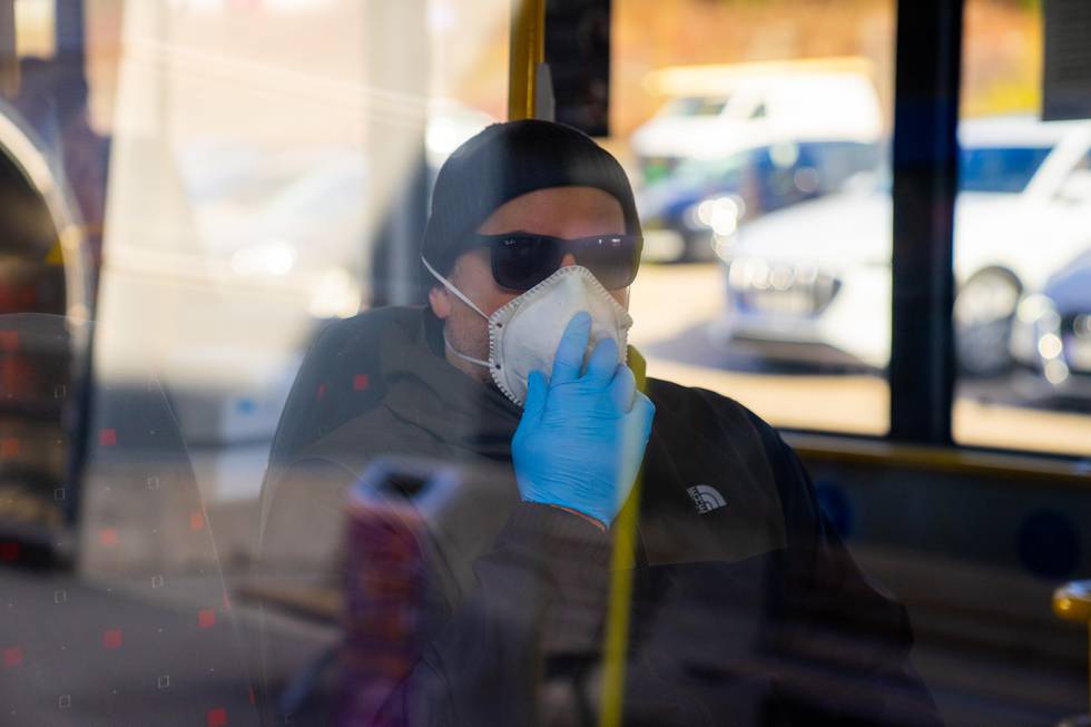 Oslo 20200330. 
Smittevern, person beskytter seg mot smitte ved bruk av mundbind og engangshansker på offentligtransport, illustrasjonsbilde.
Foto: Thomas Brun / NTB scanpix   Modellklarert
