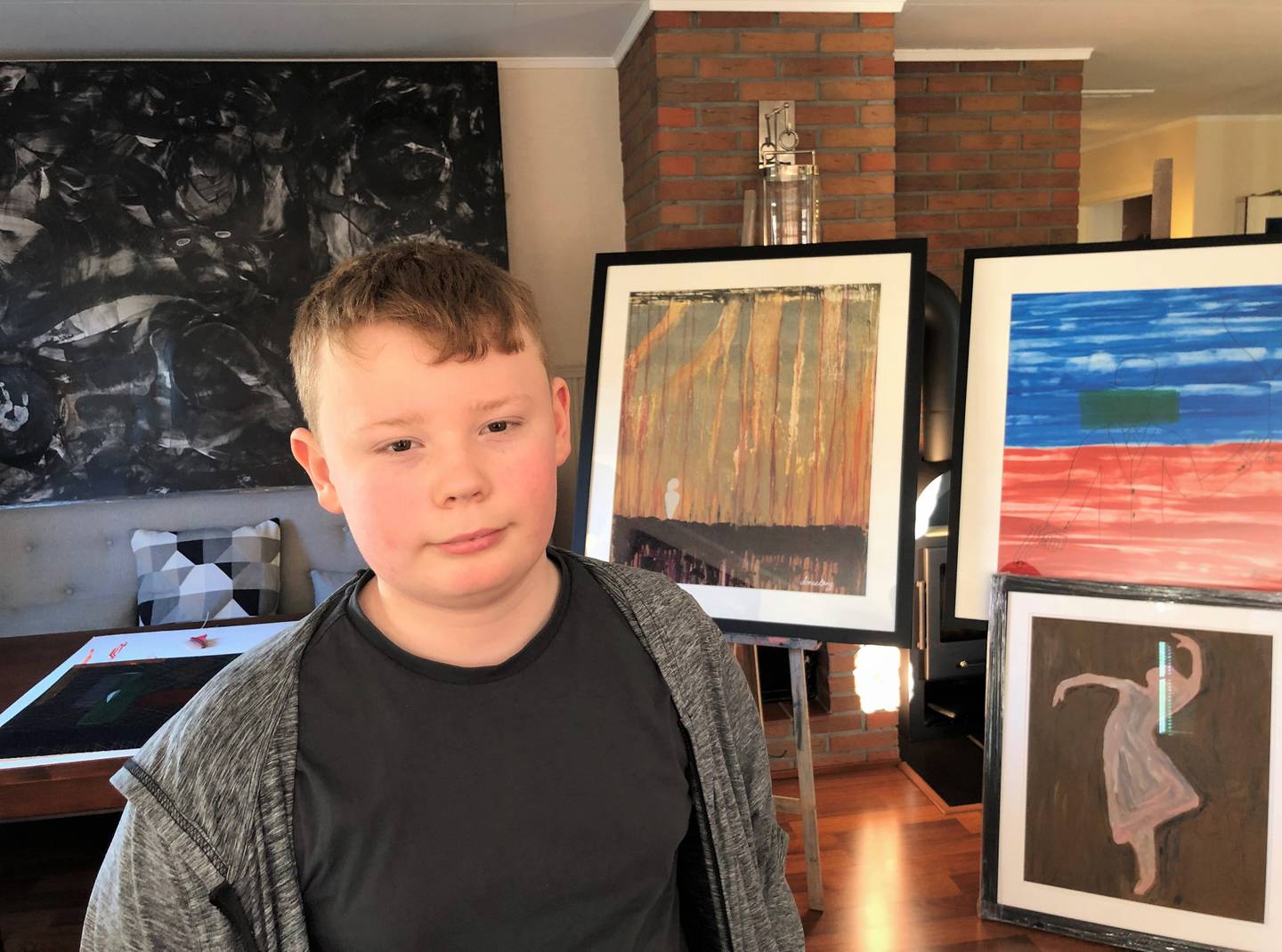 Jonas Søderlund Berg (12) viser noen av de mange bildene han har laget hittil i sitt unge kunstnerliv.