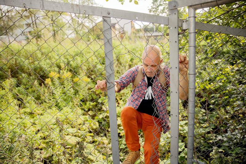 Bystyrerepresentant Harald Nissen tar ikke fem øre for å snike seg gjennom nettinggjerdet og beskue Brakkebygrenda-tomta i Gamlebyen.