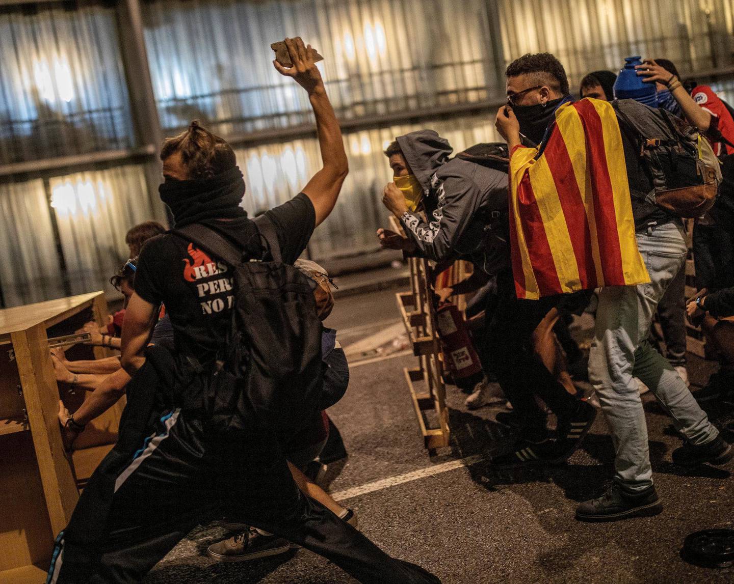 En demonstrant kaster stein mot politiet i Barcelona. FOTO: NTB SCANPIX