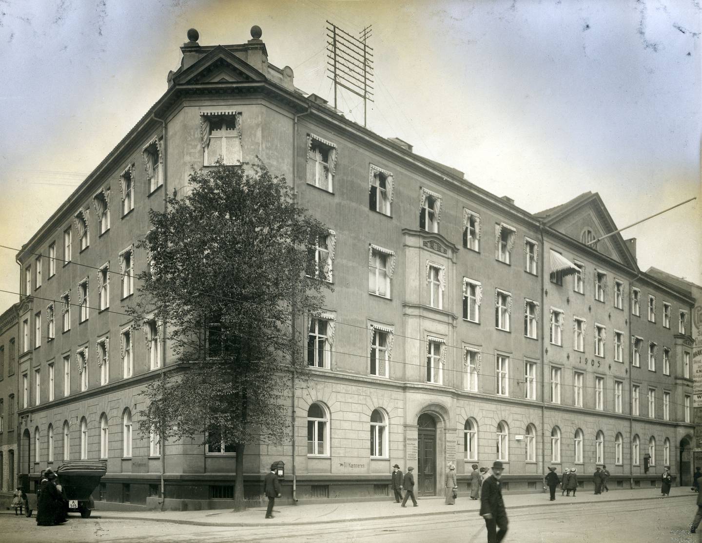 Mang en osloborger har stått i kø i Akersgata 55, Det kommunale kontorbygget i Dittenkomplekset fra 1905. Skilt på veggen med teksten «Til Kæmneren». Oslo byarkiv