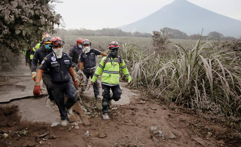 Brannmenn bærer et offer for vulkanen Fuego i Guatemala i landsbyen Los Lotes. 