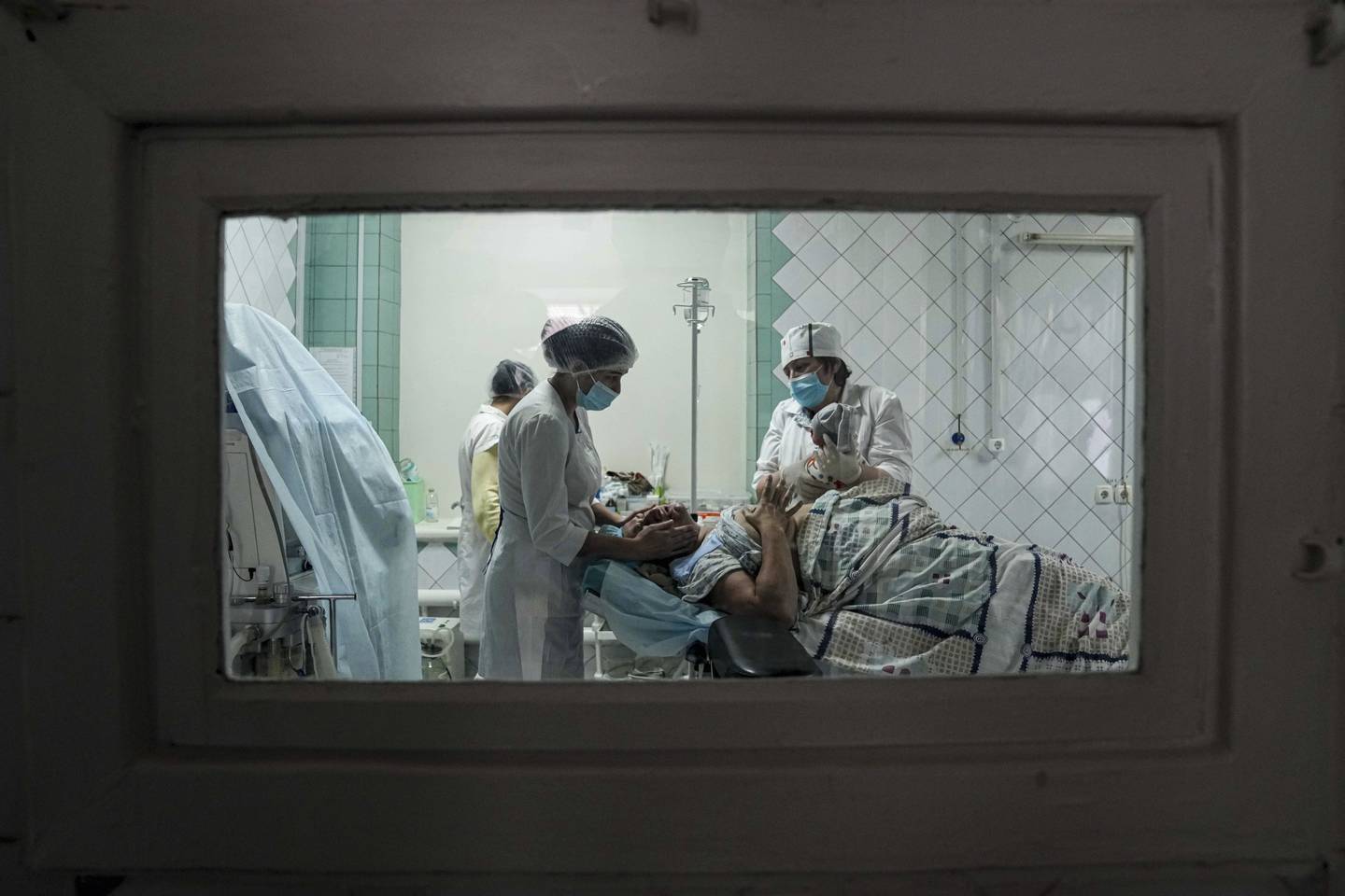 Helsepersonell viser en kvinne sitt nyfødte barn i et fødesykehus som er gjort om til en medisinsk sengepost i Mariupol.