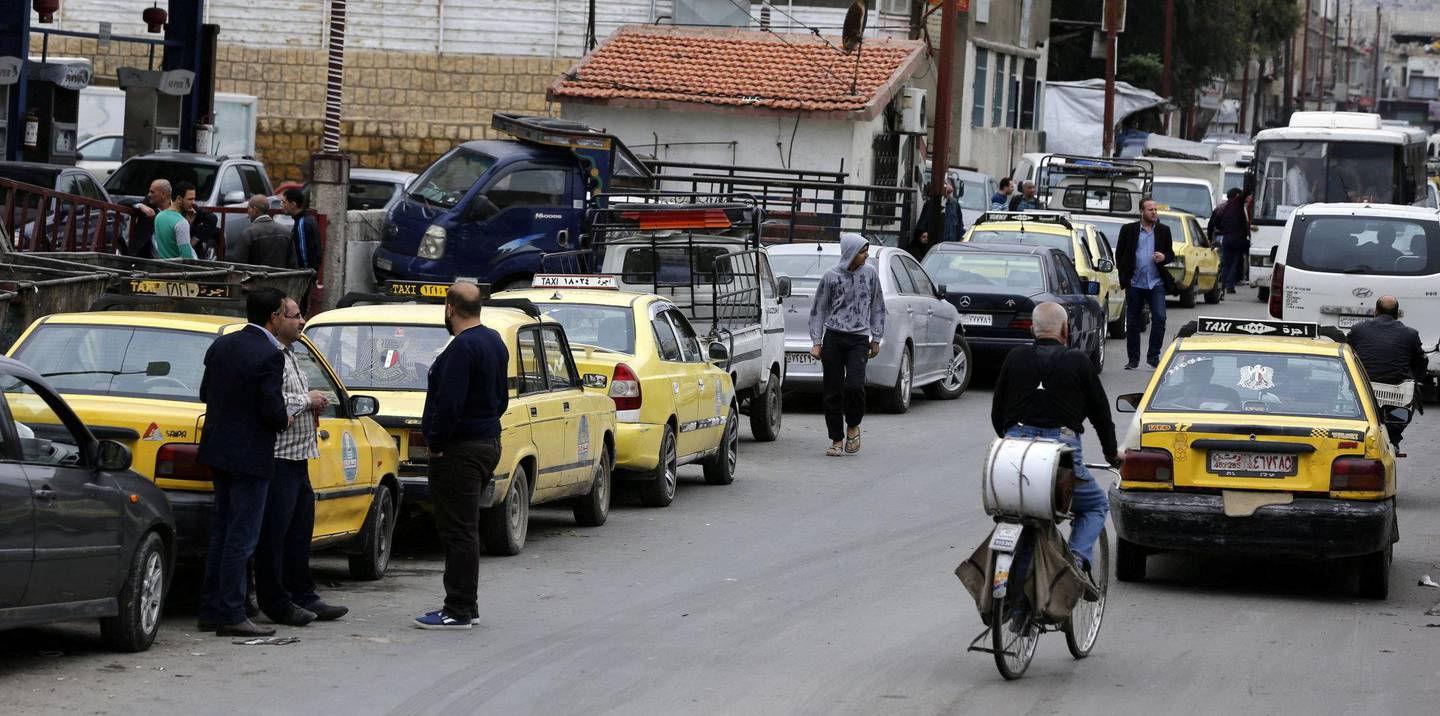 KØER: Biler i bensinkø i Damaskus. Køene er lange, og goder som mat er fremdeles dyre. Men det er tryggere i gatene. 	 FOTO: NTB SCANPIX