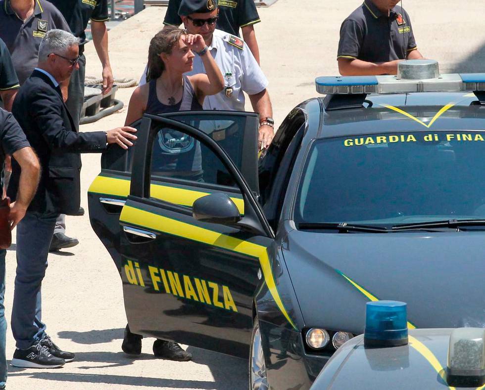 Sea-Watch 3 captain Carola Rackete, center, from Germany, enters an Italian finance police car as she arrives in the Sicilian port of Porto Empedocle, from the island of Lampedusa, Italy, Monday, July 1, 2019. Rackete has been in custody since Saturday when she defied Italy's anti-migrant interior minister, Matteo Salvini, and port authorities by steering her Sea-Watch 3 ship to Lampedusa's dock so the 40 migrants the ship rescued on June 12 could disembark. (Pasquale Claudio Montana Lampo/ANSA via AP)
