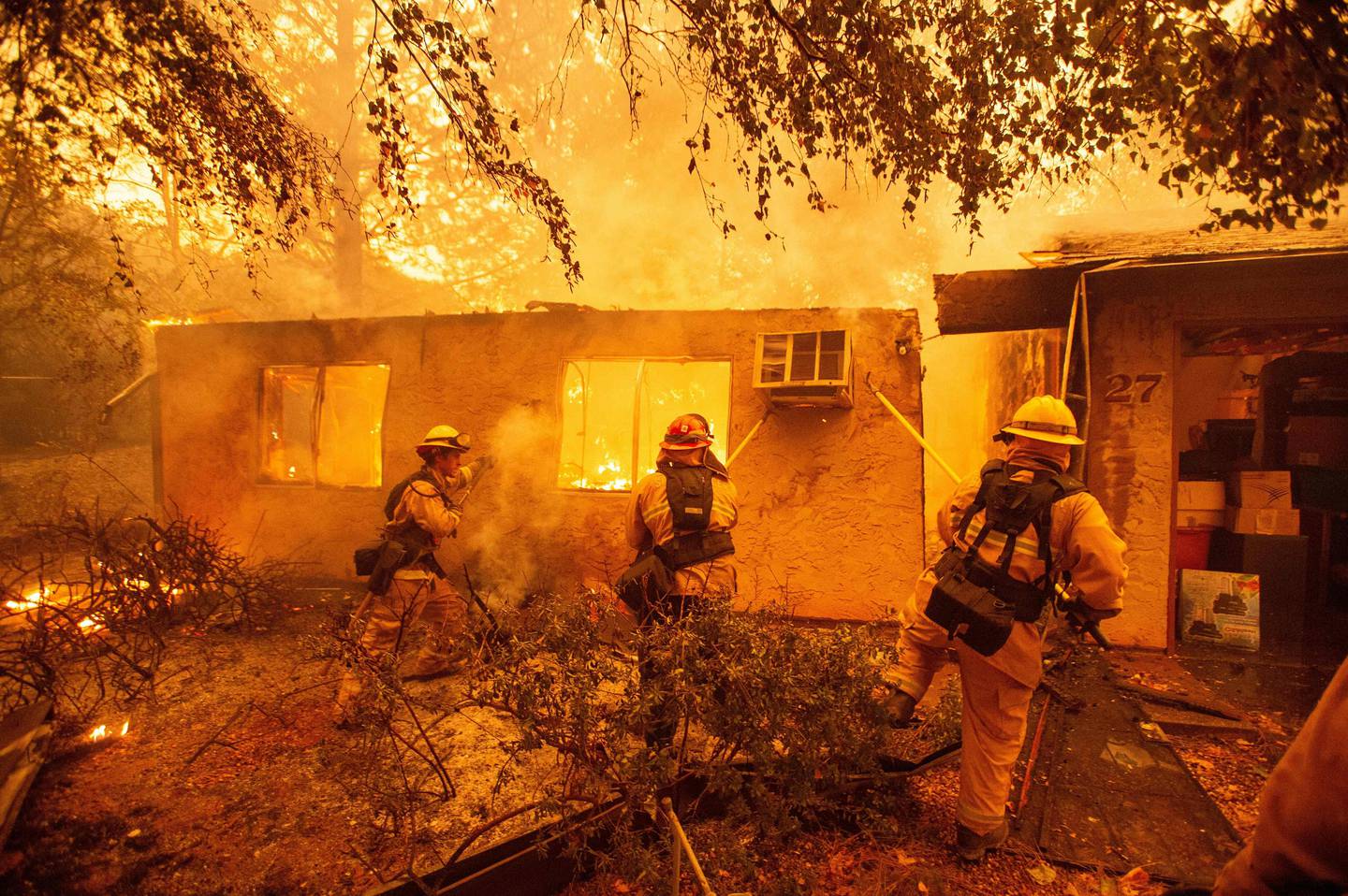 (FILES) In this file photo taken on November 9, 2018 firefighters push down a wall while battling against a burning apartment complex in Paradise, north of Sacramento, California. - US President Donald Trump on January 9, 2019 said he is cutting emergency federal aid sent to help California after devastating wildfires unless the Democratic-led state gets its "act together.""Billions of dollars are sent to the State of California for Forrest fires that, with proper Forrest Management, would never happen," Trump tweeted, initially misspelling the word forest before repeating the tweet with the word corrected."Unless they get their act together, which is unlikely, I have ordered FEMA to send no more money. It is a disgraceful situation in lives & money!" he said, referring to the Federal Emergency Management Agency. (Photo by Josh Edelson / AFP)