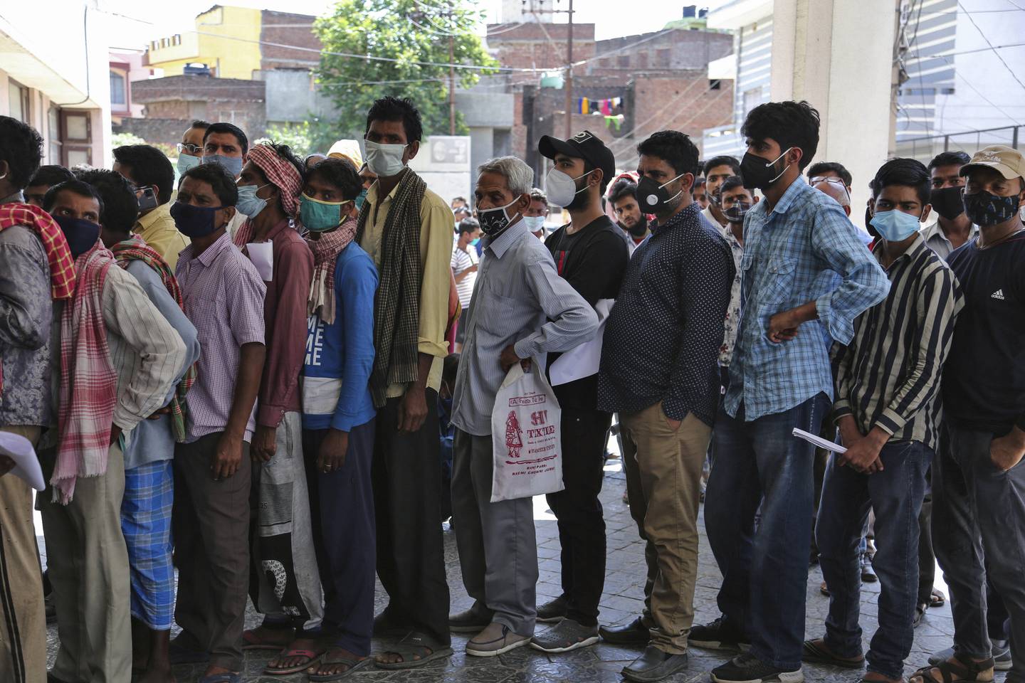 Personer står tett i tett i kø for å teste seg for koronaviruset i Jammu i India.