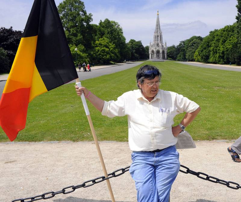 En mann holder fast i det belgiske flagget etter valget i Belgia. Flamske krefter ønsker selvstendighet. 