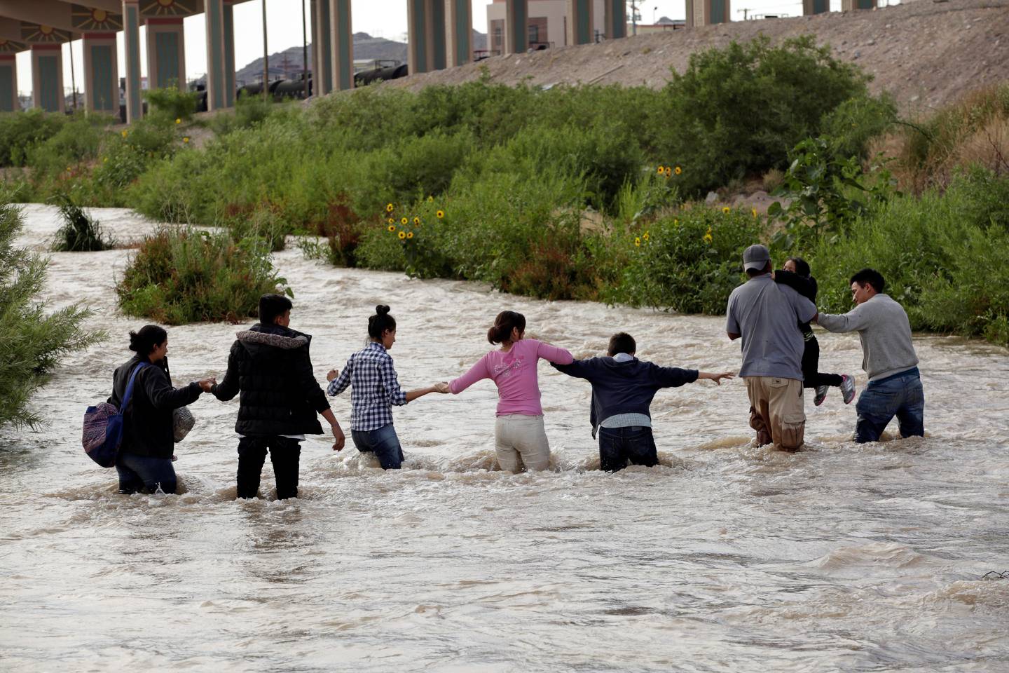 Migrants from Central America form a human chain to cross the Rio Bravo river to enter illegally into the United States to turn themselves in to request for asylum in El Paso, Texas, U.S., as seen from Ciudad Juarez, Mexico June 11, 2019. Picture taken June 11, 2019. REUTERS/Jose Luis Gonzalez