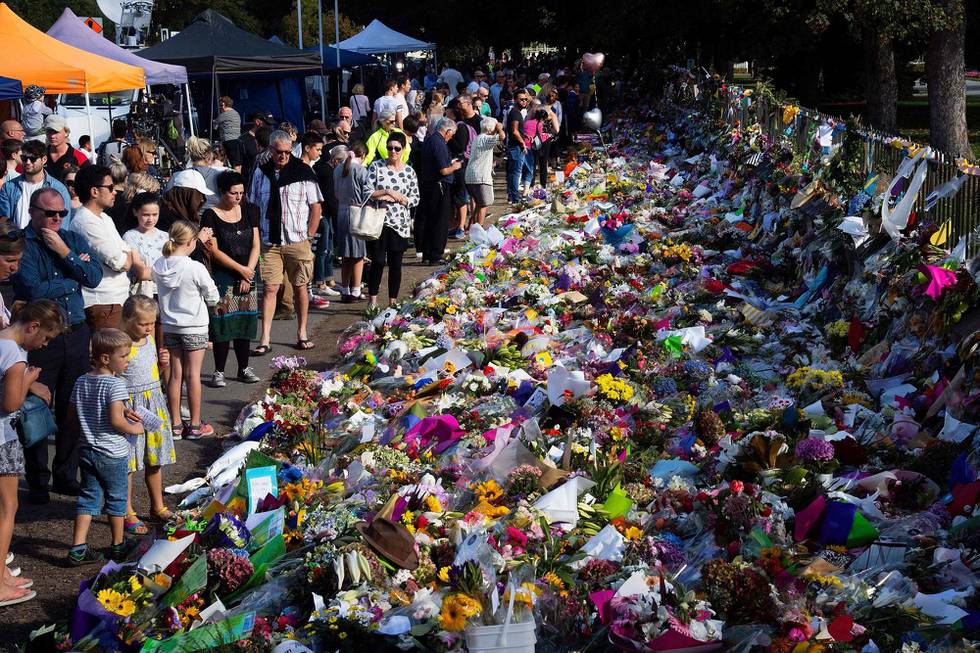 TOPSHOT - Floral tributes to those who were gunned down at the two mosques are seen against a wall bordering the Botanical Garden in Christchurch on March 19, 2019. - New Zealand Prime Minister Jacinda Ardern vowed never to utter the name of the twin-mosque gunman as she opened a sombre session of parliament with an evocative "as salaam alaikum" message of peace to Muslims. (Photo by Marty MELVILLE / AFP)